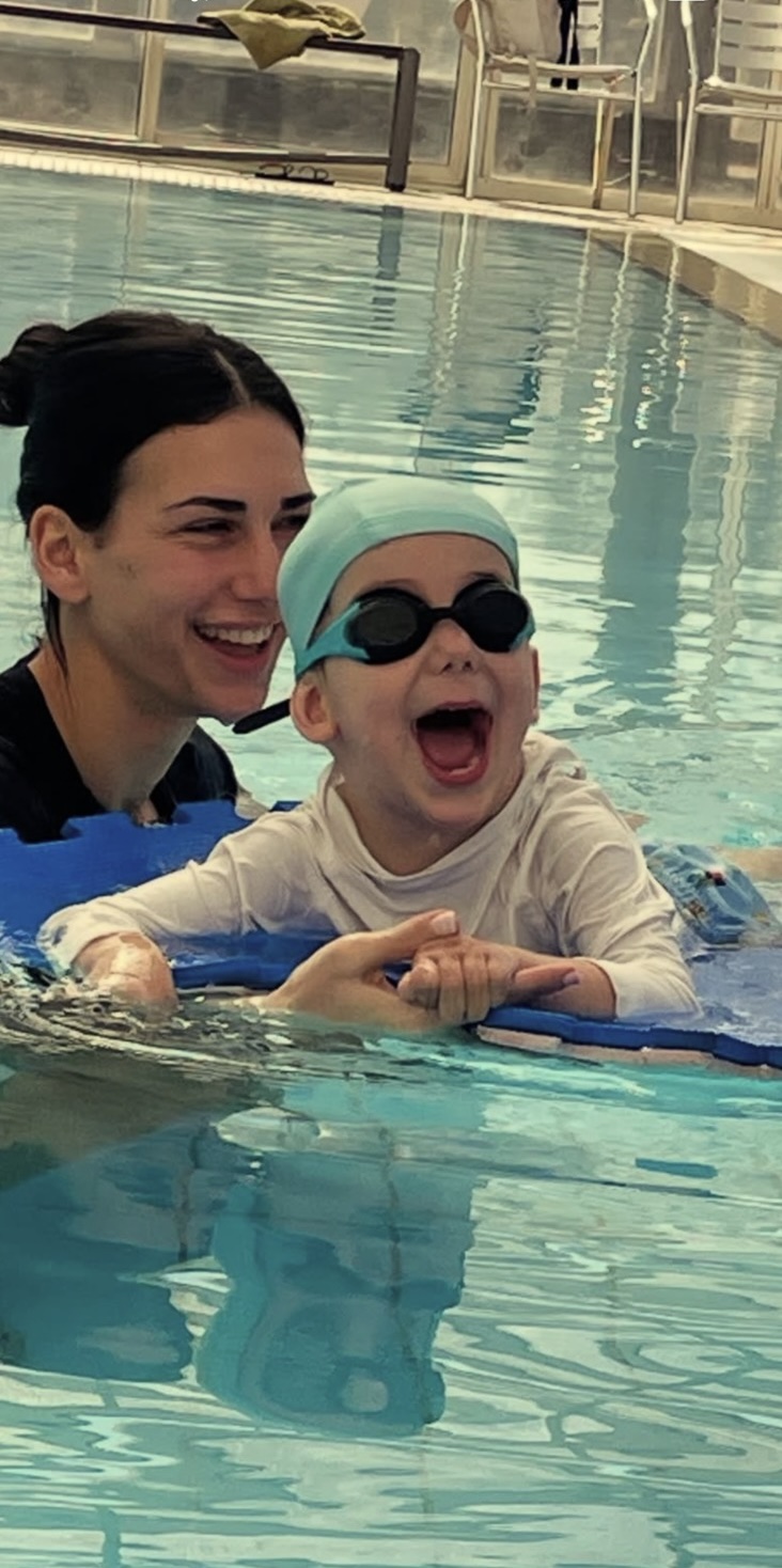 Χαρούμενο παιδί με θεραπεύτρια κατά τη διάρκεια συνεδρίας